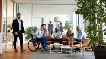 Reunión de grupo en oficina moderna con muchas plantas.