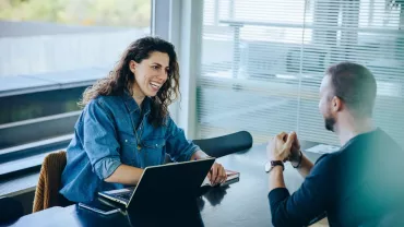 Persona sonriendo en reunión de trabajo