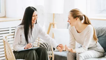 dos compañeras dándose la mano con confianza