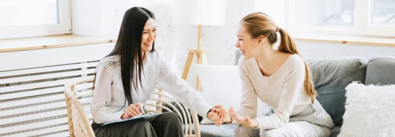 dos compañeras dándose la mano con confianza